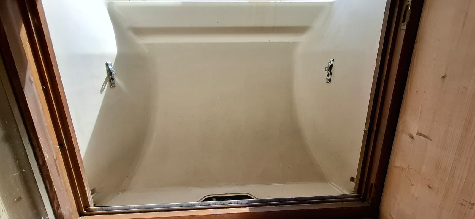 Ein sauberer Lichtschacht aus Beton und Glas, der Licht in einen Keller lässt.